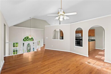 Unfurnished living room with a ceiling fan, light wood finished floors, a sink, high vaulted ceiling, and baseboards