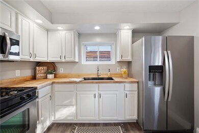 White cabinetry, butcher block countertops and sta