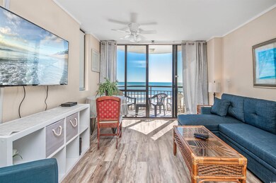 Living room featuring floor to ceiling windows, a ceiling fan, wood finished floors, a water view, and ornamental molding