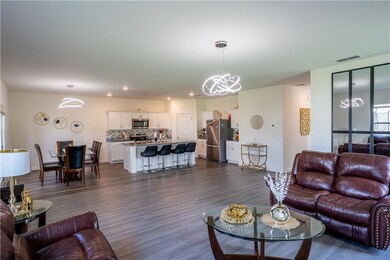 Living room featuring a chandelier, dark wood-type flooring, and recessed lighting
