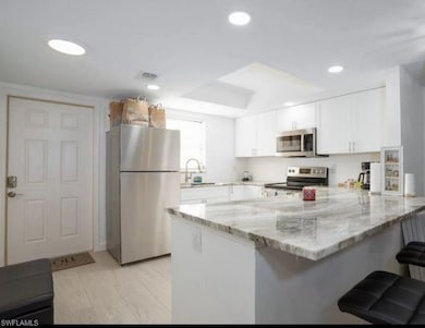 Kitchen featuring white cabinetry, appliances with