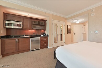 Bedroom featuring refrigerator, bar with sink, orn