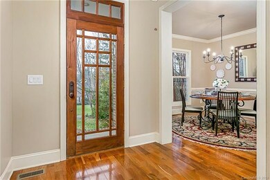 wide open and bright entrance with it's gleaming walnut floors opens up to living room and dining room
