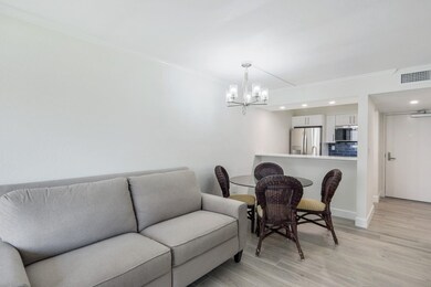 Living room featuring a chandelier, crown molding, and light wood-type flooring