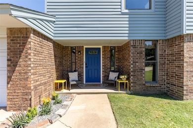 View of exterior entry with a porch, brick siding, and a lawn