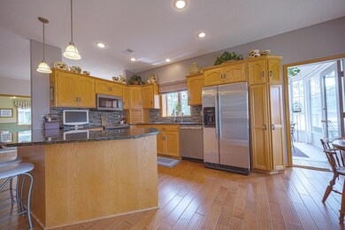 Open design living room/kitchen/dining room area has 9 ft ceilings, granite counter tops, stainless steel appliances, real hardwood flooring, and a gorgeous gas fireplace.