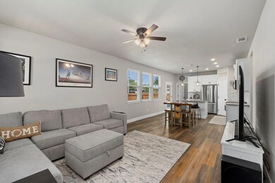 Living area featuring ceiling fan, dark wood-type