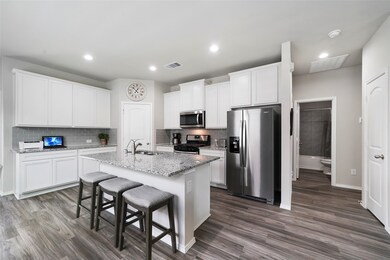 Wow! This kitchen is awesome with granite island with counter seating, staggered white cabinets for an upgraded look, gorgeous grey subway tile backsplash, and stainless steel appliances.