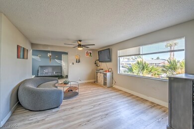 Living area featuring ceiling fan, baseboards, a t