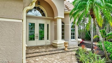 Doorway to property with stucco siding, french doors, and a tile roof