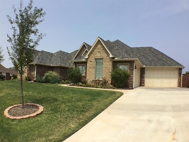 View of front facade with concrete driveway, a garage, a front lawn, and brick siding
