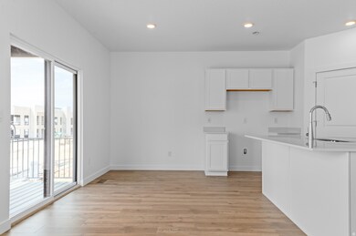 Kitchen featuring white cabinets, light wood-type flooring, recessed lighting, and light stone counters