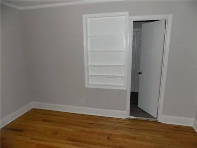 Unfurnished bedroom with crown molding and hardwoo