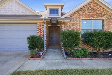 Entrance to property with brick siding, a shingled roof, and an attached garage