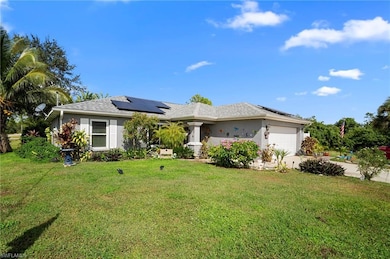 View of front of home featuring a front lawn, roof mounted solar panels, a garage, and stucco siding