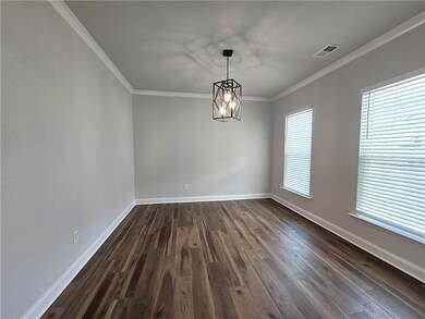 Unfurnished dining area with crown molding, dark wood-type flooring, and a chandelier