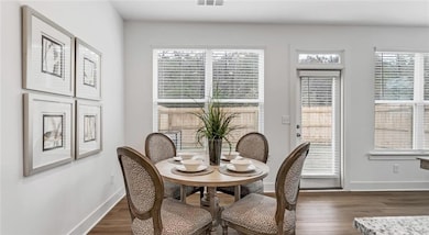 Dining area with baseboards, dark wood-style flooring, and plenty of natural light