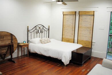 This bedroom features hardwood floors, a decorativ
