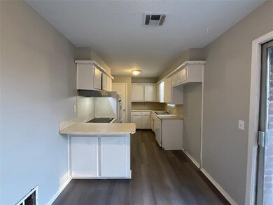 Kitchen featuring kitchen peninsula, white cabinet