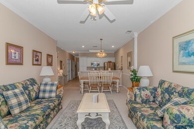 Carpeted living room featuring crown molding and c