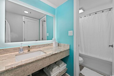 Full bathroom with tile patterned floors, vanity, shower / bath combo, and toilet
