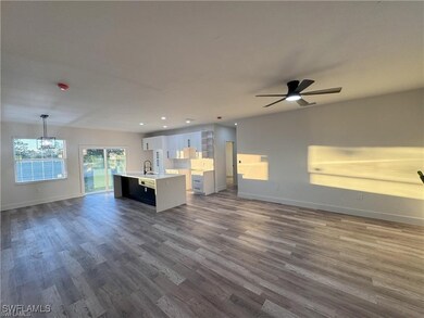 Unfurnished living room with baseboards, dark wood