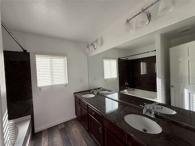 Bathroom with double vanity, wood finished floors,