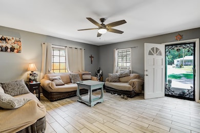 Living area with a ceiling fan and light wood-style floors