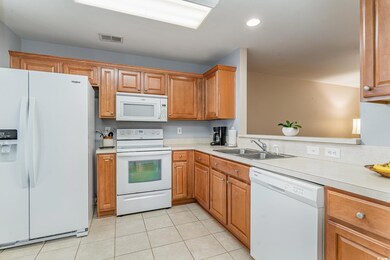 Kitchen featuring white appliances, sink, and ligh