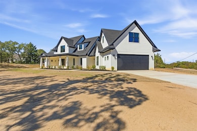 Modern farmhouse with covered porch, concrete driveway, a garage, and board and batten siding