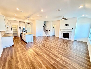 Kitchen with white cabinets, visible vents, a sink, and a fireplace