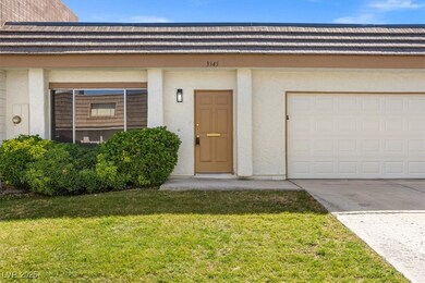 Entrance to property with a lawn, a garage, drivew