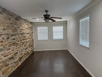 Unfurnished room featuring ceiling fan, dark wood-
