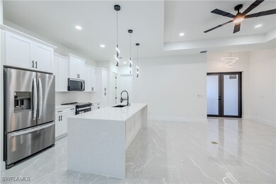 Kitchen with white cabinets, a sink, recessed ligh