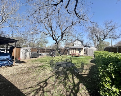View of yard with an outbuilding, fence, and a sto
