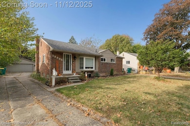 View of front of property with an outbuilding, a front lawn, a chimney, brick siding, and a garage