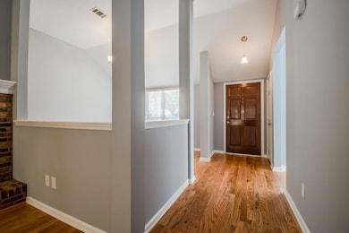 Corridor with visible vents, baseboards, wood fini