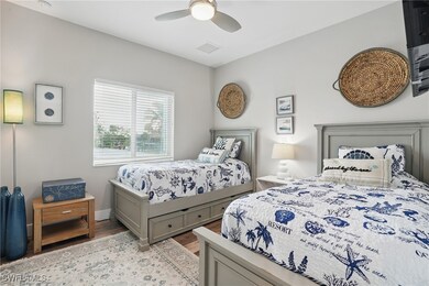 Bedroom featuring light wood-type flooring, a ceiling fan, and baseboards