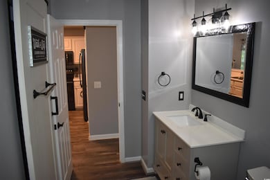 Bathroom with wood finished floors, baseboards, va