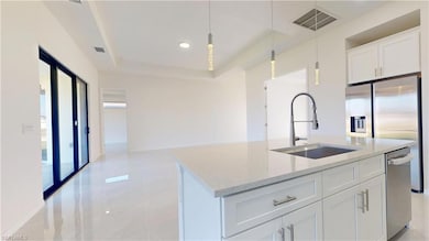 Kitchen featuring visible vents, a sink, white cab