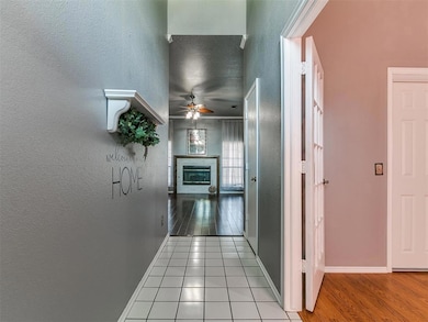 Corridor with wood finished floors, baseboards, and a textured wall