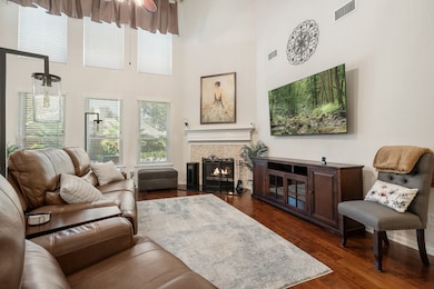 This charming two-story brick home features a well-maintained front yard with mature trees and landscaping. It has a double garage and a welcoming entrance, perfect for families seeking a comfortable and inviting residence.