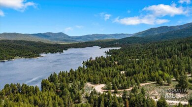 View of mountain background featuring a heavily wooded area and a large body of water