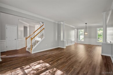 Unfurnished living room with crown molding, dark h