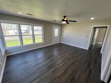 Unfurnished living room featuring dark wood-type f