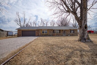 Single story home with a garage, brick siding, fen