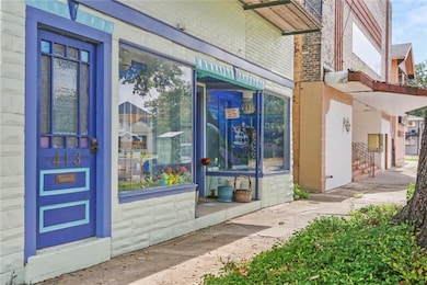Front door entrance on the left to the foyer/stairs leading up to the apartment.