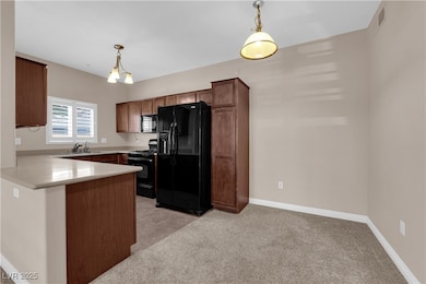Kitchen with black appliances, a peninsula, decora