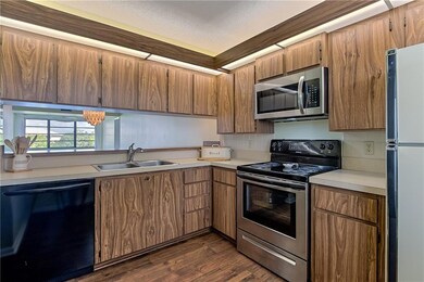 Wood flooring in kitchen and lots of wood cabinets