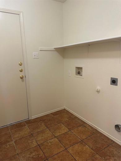 Washroom with hookup for a washing machine, gas dryer hookup, hookup for an electric dryer, and dark tile patterned floors